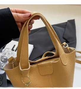 Detailed macro of pebble grain leather handle and premium gold hardware on tote bag