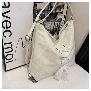 Detail of cream white leather tote with marble texture, lace bow and silver chain strap