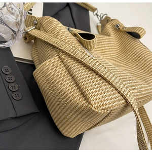 Close-up of woven straw tote bag texture with silver metal zipper and adjustable strap