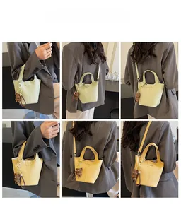 Litchi texture bucket bags in green and yellow with bear charms shown on models