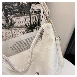 Detail of silver zipper closure and marbled texture on cream white tote bag