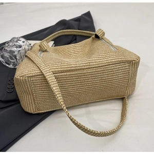 Close-up of woven straw tote bag texture with zipper closure and shoulder strap