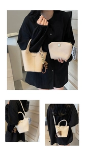 Detail of cream bucket bag set featuring lychee grain leather and bear charm