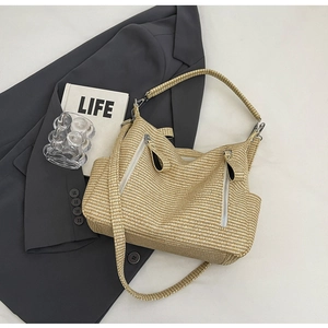 Detail of hand-woven straw tote bag texture with decorative dual metal zippers