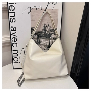 Macro shot of cream white faux leather texture and silver chain on Hobo shoulder bag