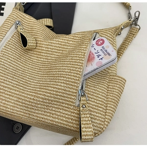 Detailed view of woven texture and front zipper pocket on a beige large tote bag