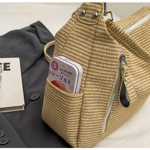 Close-up of woven tote bag texture featuring a functional side pocket and metal zipper