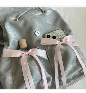 Detail of gray velvet backpack pockets showing large capacity for phone and perfume