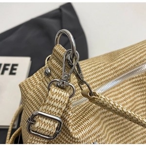 Detail of high-quality silver metal hardware and woven texture on a beige tote bag
