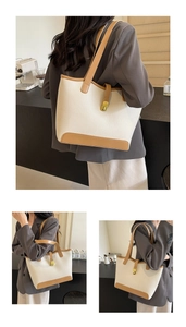 Detail of minimalist tote bag featuring cream pebbled texture and tan leather trim