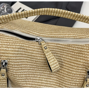 Macro shot of hand-woven beige straw texture with silver zipper detail on tote bag
