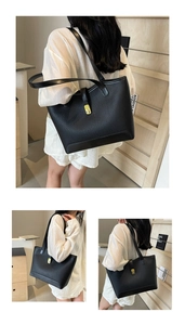 Close-up of a black lychee grain leather tote bag with a golden turn-lock closure