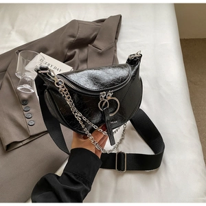 Détail du sac selle en cuir plissé noir avec chaîne argentée et large sangle nylon