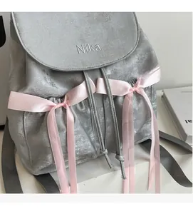 Detail of grey velvet backpack featuring pink silk ribbons and Nika embroidery
