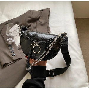 Détail du sac selle en cuir craquelé brillant avec chaîne argentée et large sangle