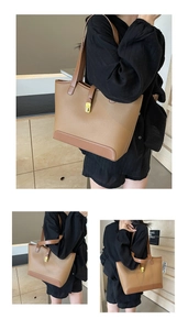 Detail of large brown canvas tote bag featuring lychee grain texture and gold buckle