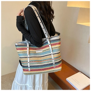Close-up of rainbow striped woven tote bag with silver leather straps and metal eyelets