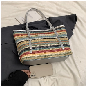 Detailed top view of striped woven tote bag with silver metallic trim and rivet details