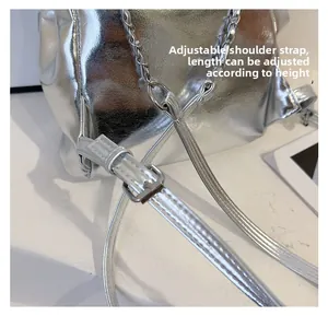 Detail view of the adjustable silver metallic strap with a polished metal buckle closure