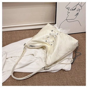 Detail of water-ripple texture fabric and lace-up ribbon design on a creamy white tote bag