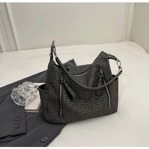 Detail of grey textured woven tote bag showing silver zippers and functional side pockets