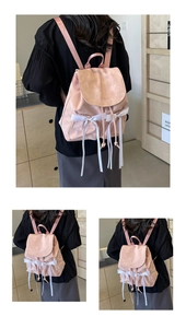 Close-up of pink nylon backpack featuring white lace bows and Nika brand logo detail