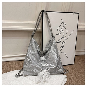 Close-up of silver tote bag with lace-up ribbon detail and chic metallic finish