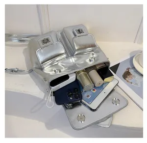 Silver metallic backpack showing interior storage capacity with phone and cosmetics