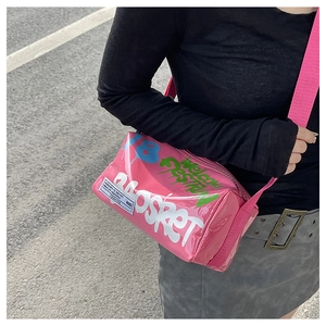 Detail of pink jelly crossbody bag with graffiti print and wide fabric shoulder strap