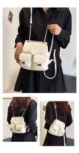 Detail of white leather mini backpack with heart buckle and metal chain straps