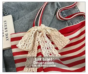 Detail van de rood-wit gestreepte canvas tote bag met decoratieve kanten lintstrik