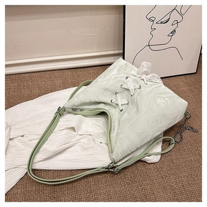 Detail view of mint green marble tote bag with lace bow and crossbody strap