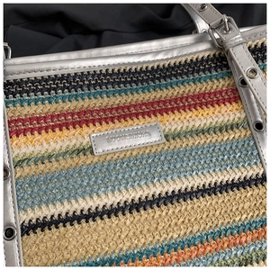 Detailed close-up of rainbow striped woven tote bag with silver metallic trim and logo