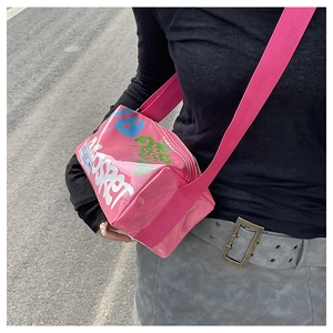 Close-up of pink jelly bag with graffiti print and wide adjustable shoulder strap