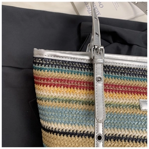 Detail of colorful rainbow straw tote bag featuring silver metallic leather straps