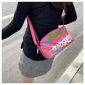 Close-up of bright pink jelly crossbody bag with graffiti art and wide canvas strap