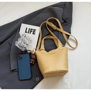 Top view of yellow lychee grain bucket bag with bear pendant and adjustable strap