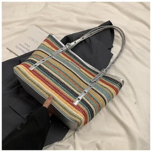 Detail of multi-color woven straw tote bag with silver leather trim and adjustable straps