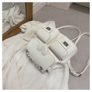 Detail of white PU leather bucket backpack with metal chain and heart-shaped stitching