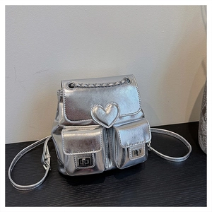 Detail of silver metallic backpack featuring heart stitching and dual front pockets