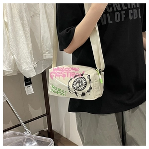 Detail of beige nylon crossbody bag with artistic graffiti print and wide fabric strap