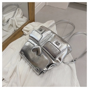 Detail of silver metallic bucket backpack with heart accents and stylish metal chains