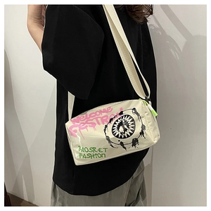 Detail of trendy creamy-white square crossbody bag with vibrant graffiti and wide strap