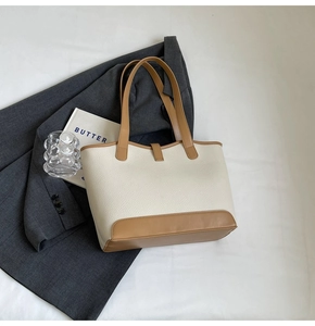 Close-up of litchi grain texture and metal buckle on the bicolor tote bag