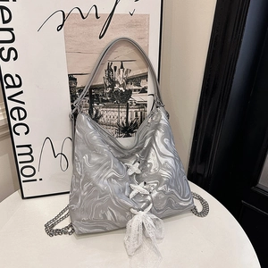 Silver metallic tote bag with lace bow details and marble texture chain strap