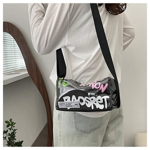Detail of black graffiti cylinder bag featuring wide textile strap and glossy finish