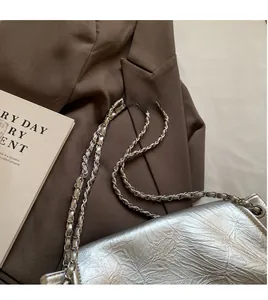 Detail shot of silver pleated tote bag featuring high-quality metallic chain strap
