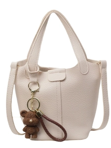 Chic beige bucket bag with litchi texture and cute brown crochet bear charm accessory