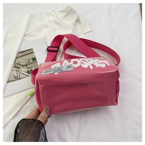 Close-up of bright pink glossy jelly bag with white graffiti lettering and woven patch