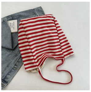 Flat lay of red and white striped canvas tote bag with delicate lace trim detail